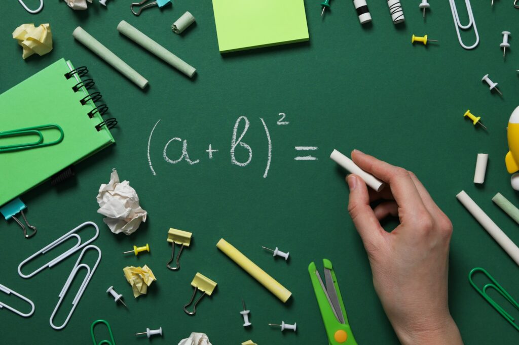 School supplies on a school board with a formula written in chalk